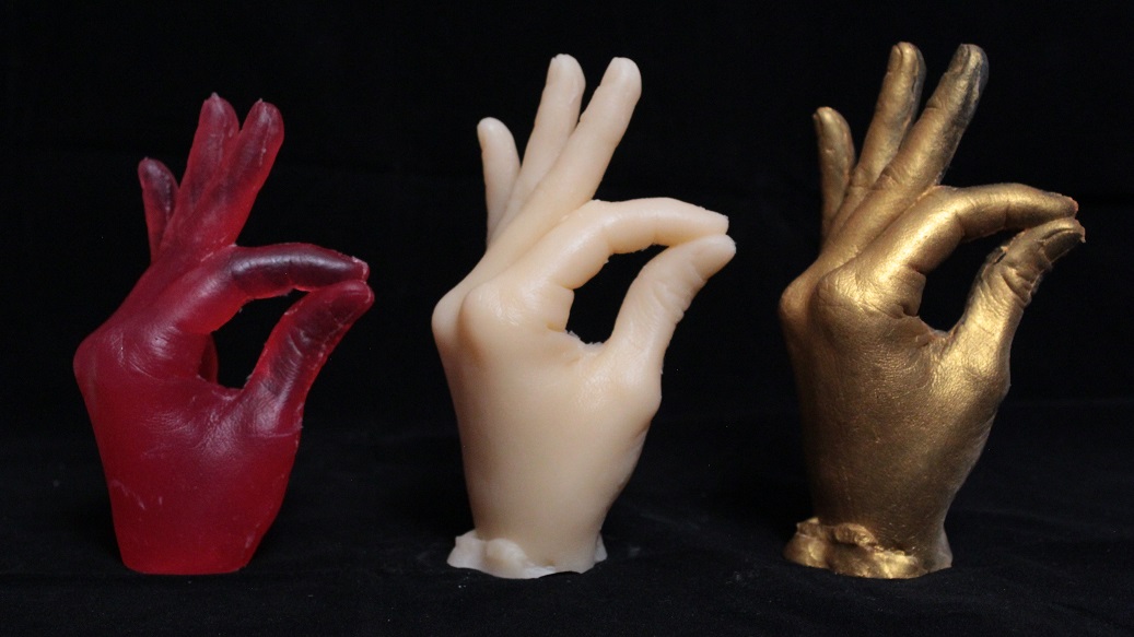 two plastic cast: red and pale.  one plaster cast spray painted gold
