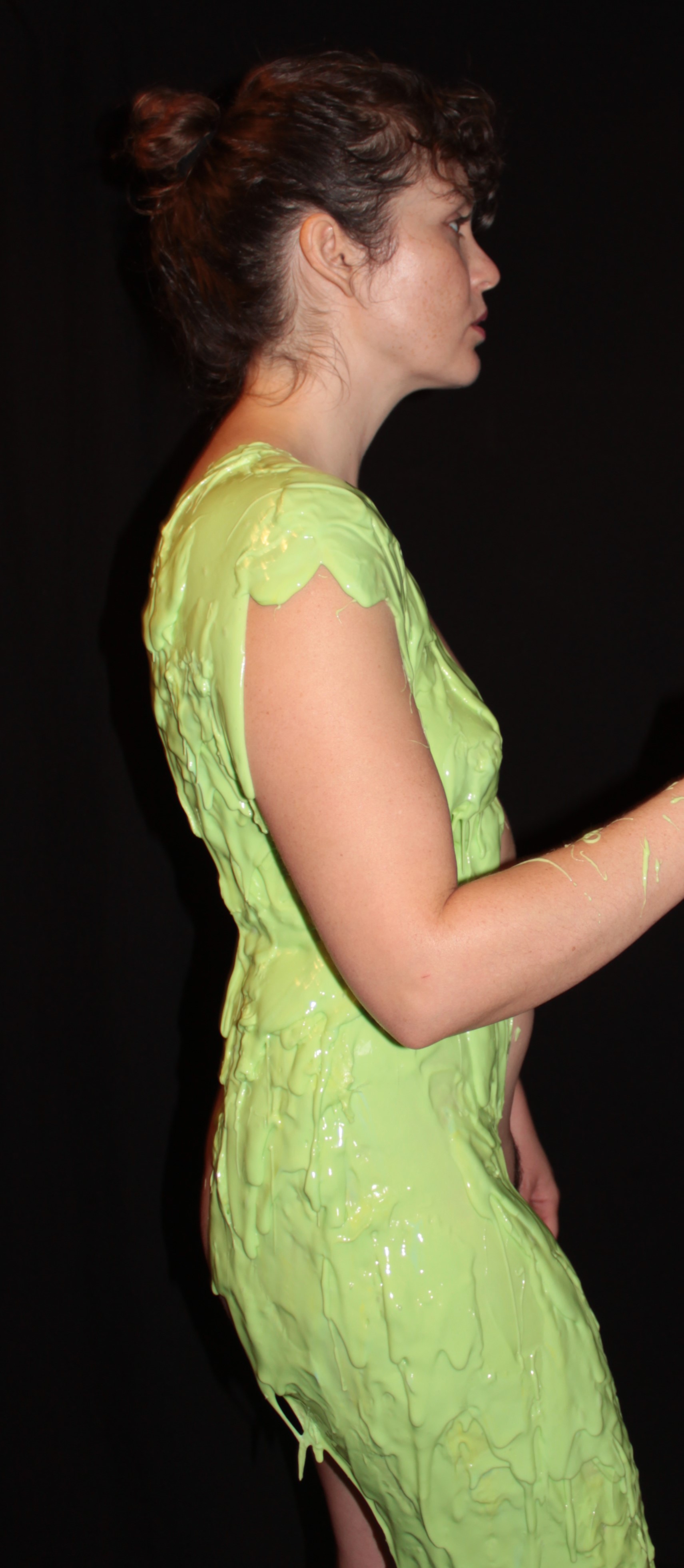 Nude female in profile, covered with silicone mold material from shoulders to lower thigh