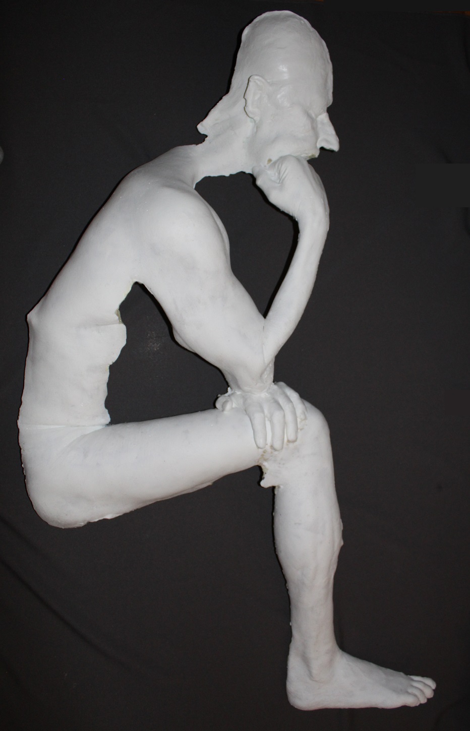 white plastic casting of male in thinker pose