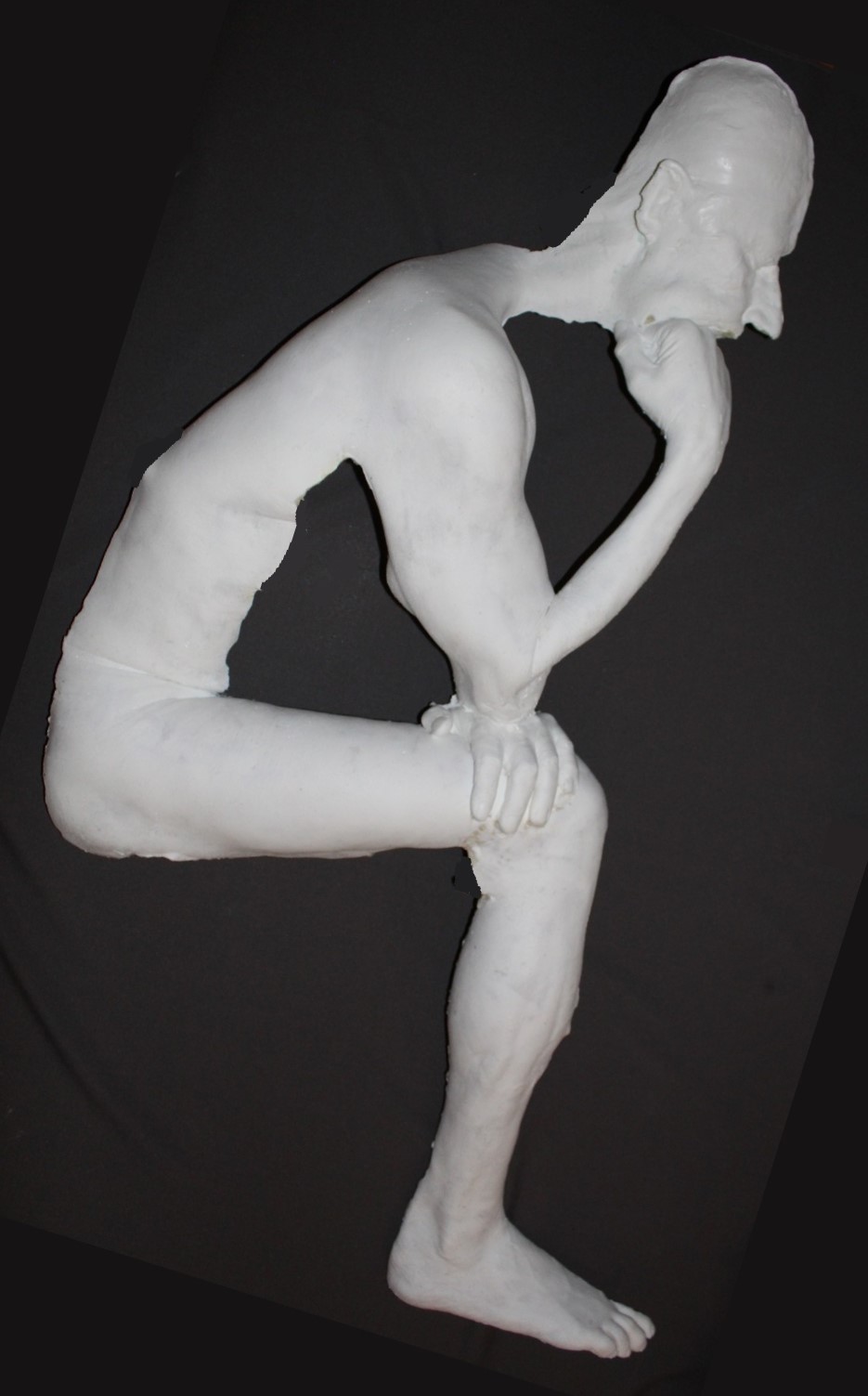 white plastic casting of nude male in thinker pose.